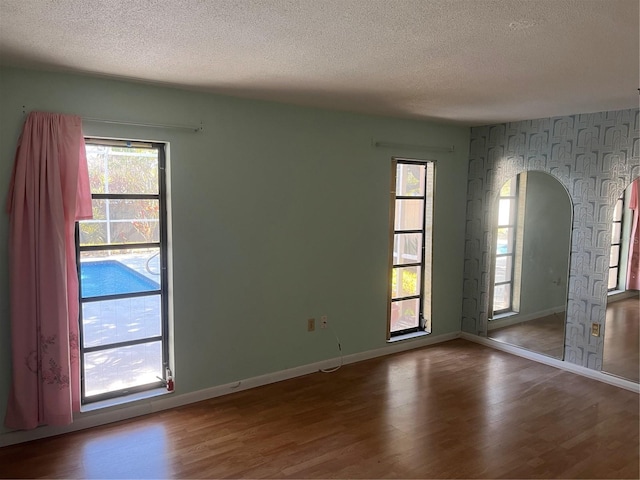 spare room with hardwood / wood-style floors and a textured ceiling