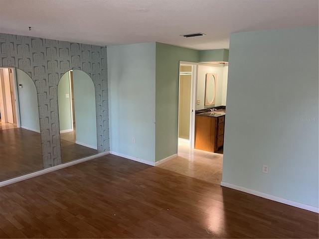 empty room featuring sink and dark wood-type flooring