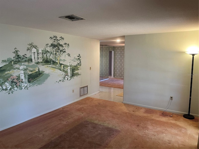 carpeted empty room with a textured ceiling