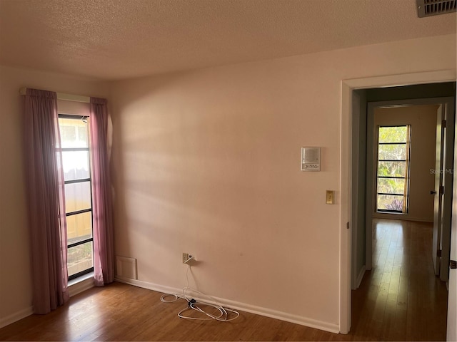 spare room with wood-type flooring and a textured ceiling