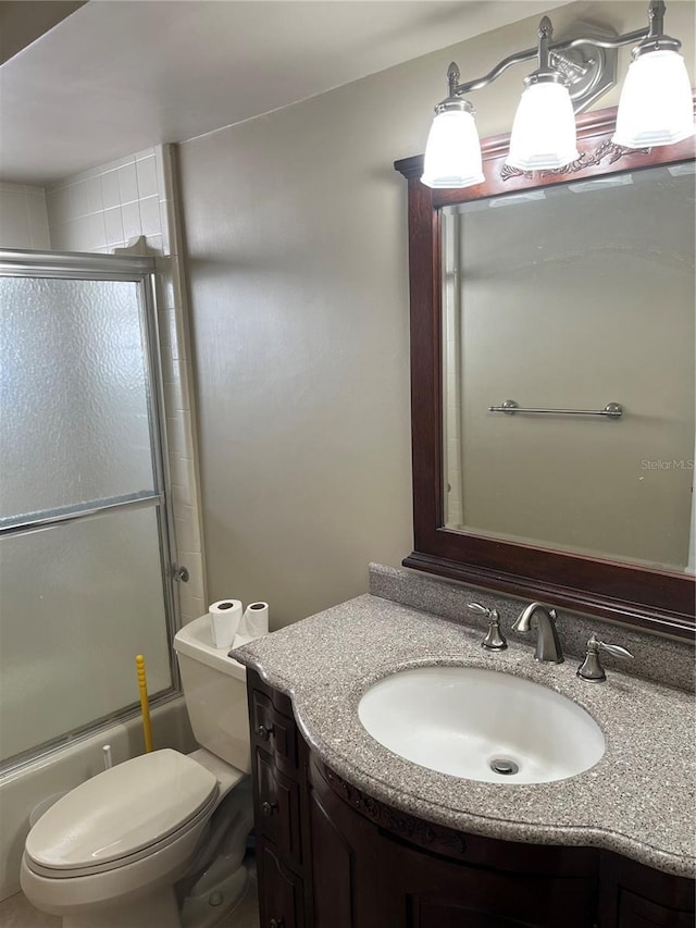 full bathroom featuring vanity, toilet, and enclosed tub / shower combo