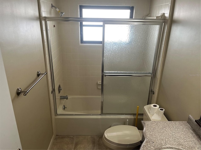 full bathroom featuring shower / bath combination with glass door, tile patterned floors, vanity, and toilet