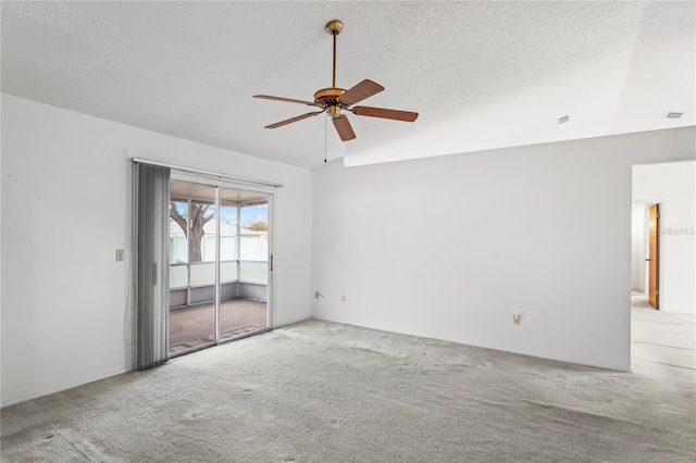 carpeted empty room featuring ceiling fan, lofted ceiling, and a textured ceiling