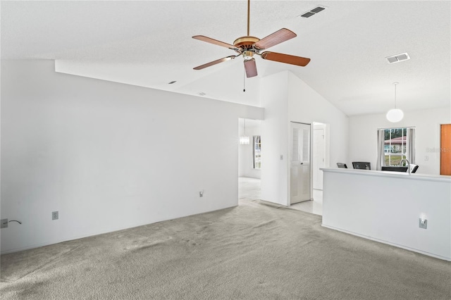 unfurnished living room with light colored carpet, ceiling fan, and vaulted ceiling