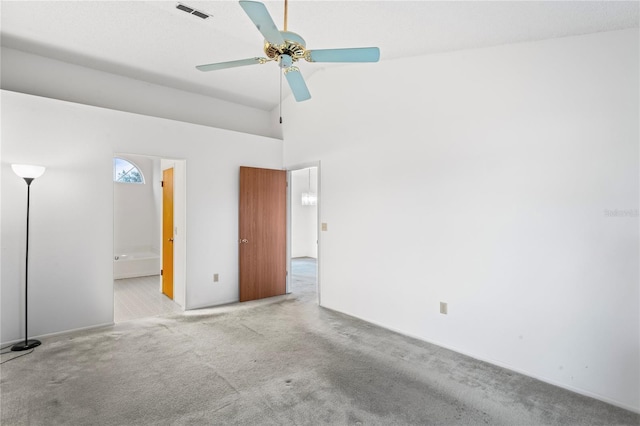 empty room with high vaulted ceiling, light colored carpet, and ceiling fan