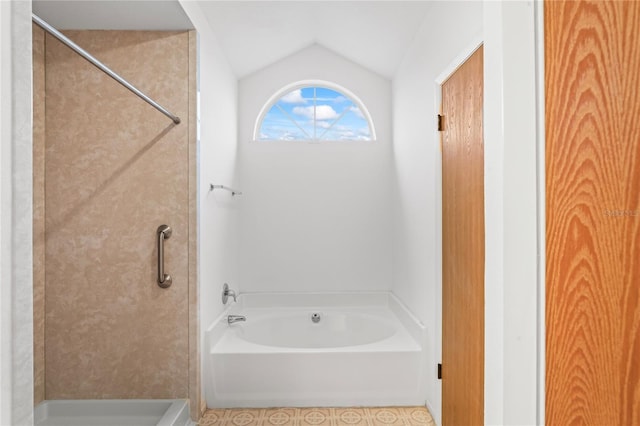 bathroom with lofted ceiling and a tub to relax in