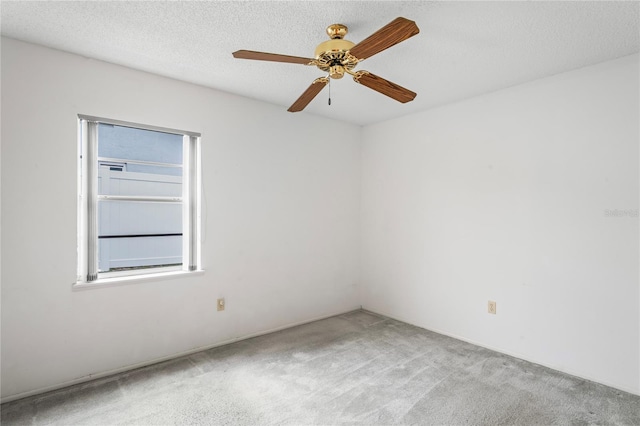 empty room featuring a textured ceiling, ceiling fan, and light carpet