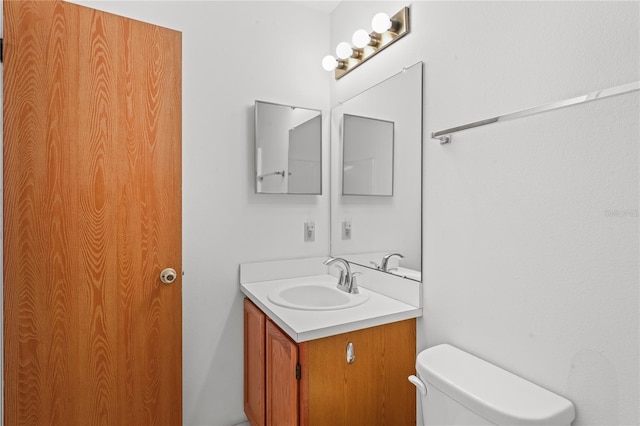 bathroom featuring toilet and vanity