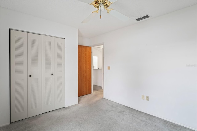 unfurnished bedroom featuring light colored carpet, ceiling fan, and a closet