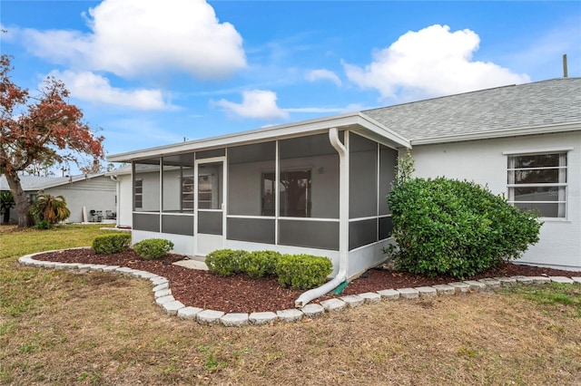 back of house with a yard and a sunroom