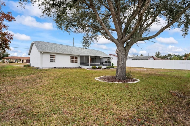 back of property with a yard and a sunroom