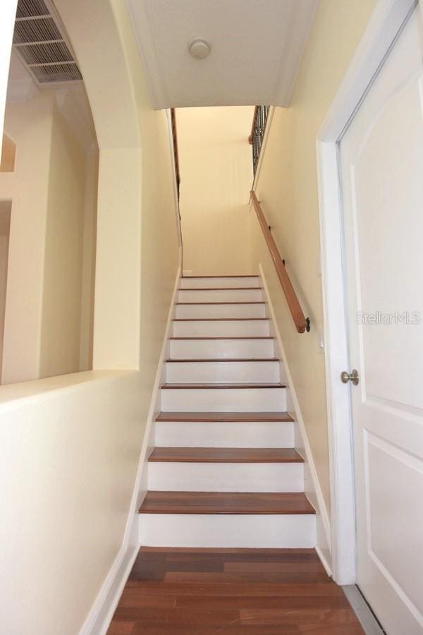 staircase with crown molding and hardwood / wood-style flooring