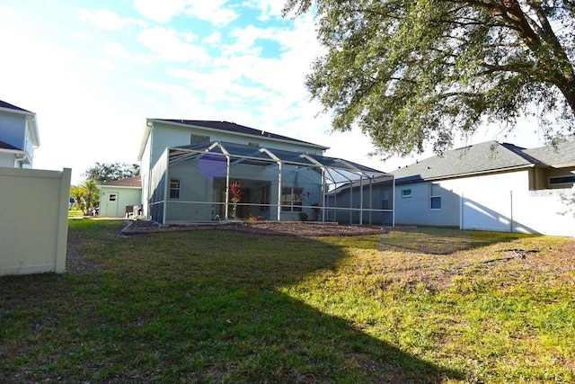 back of property featuring glass enclosure and a lawn