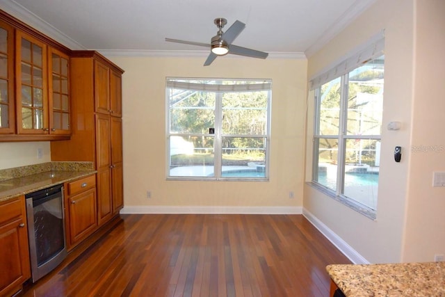 kitchen featuring ceiling fan, beverage cooler, light stone countertops, dark hardwood / wood-style flooring, and crown molding