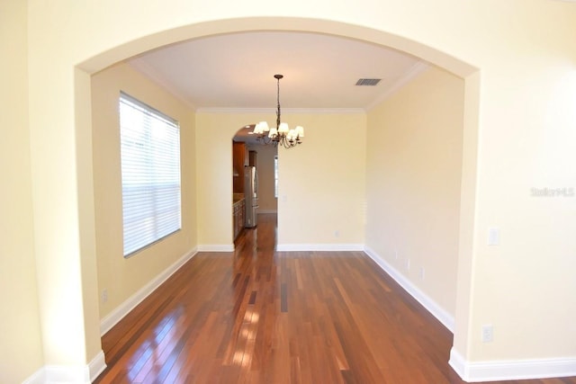 unfurnished dining area with a notable chandelier, dark wood-type flooring, and crown molding