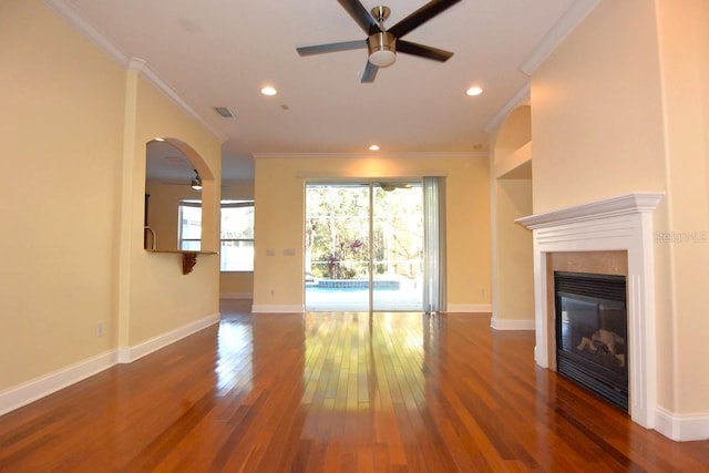 unfurnished living room featuring ornamental molding, ceiling fan, plenty of natural light, and dark wood-type flooring