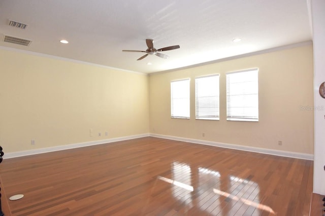 empty room featuring ceiling fan, crown molding, and dark hardwood / wood-style floors