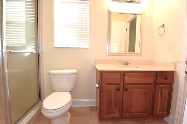 bathroom featuring toilet, vanity, and a shower with shower door