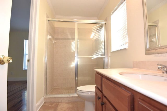 bathroom with ornamental molding, vanity, a shower with shower door, and toilet