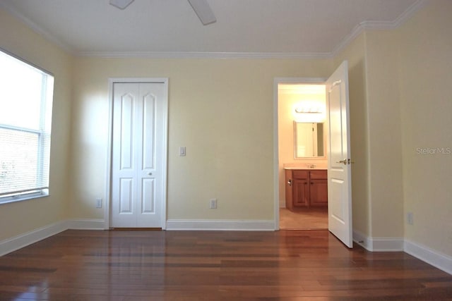 unfurnished bedroom featuring ornamental molding, dark hardwood / wood-style flooring, a closet, and ceiling fan