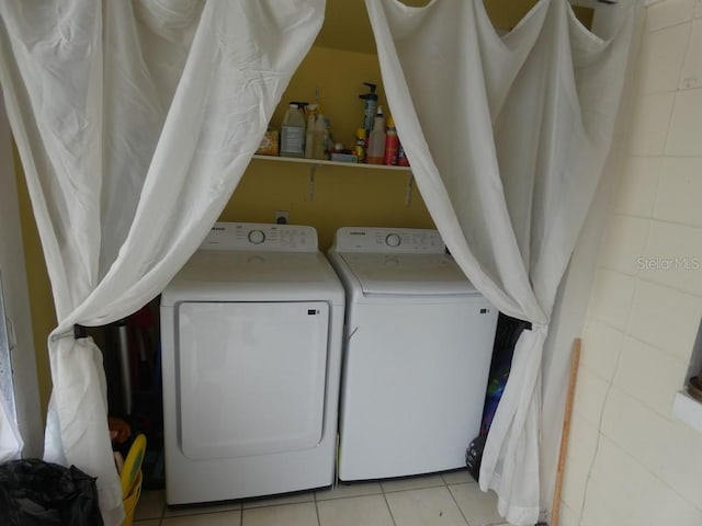 washroom with separate washer and dryer and light tile patterned floors