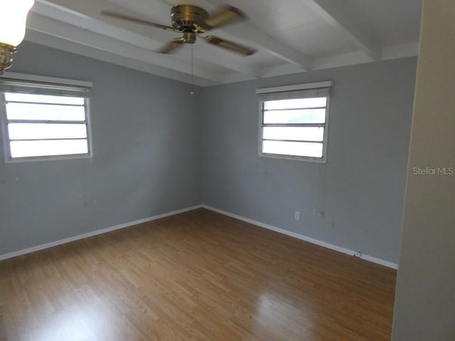 unfurnished room with hardwood / wood-style flooring, beam ceiling, and ceiling fan