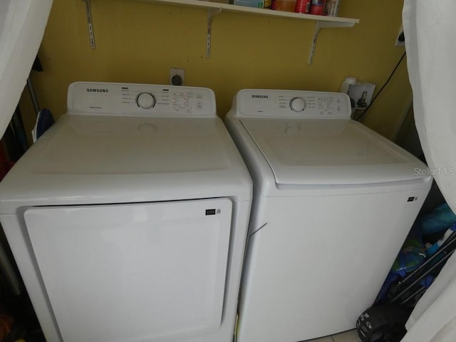 laundry room with tile patterned floors and washer and clothes dryer