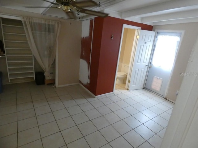 unfurnished bedroom with ensuite bathroom, beam ceiling, ceiling fan, and light tile patterned floors