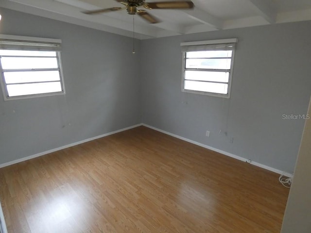 spare room with hardwood / wood-style floors, ceiling fan, and beam ceiling