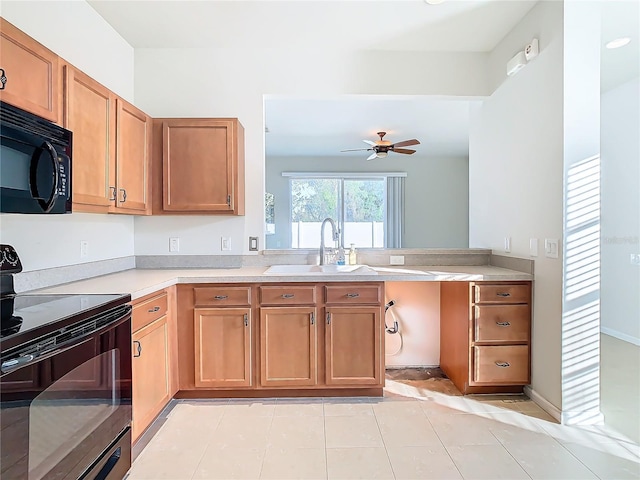 kitchen featuring sink, ceiling fan, light tile patterned floors, kitchen peninsula, and black appliances