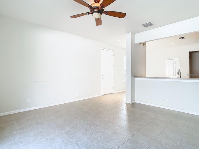 spare room featuring ceiling fan, sink, and light tile patterned floors