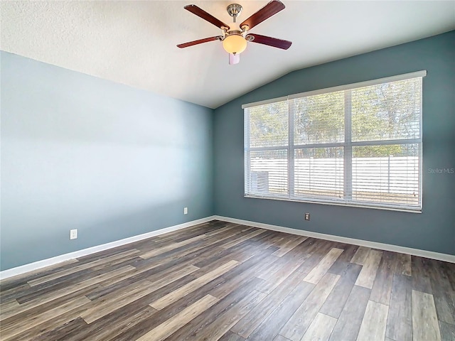 unfurnished room with ceiling fan, vaulted ceiling, dark hardwood / wood-style flooring, and plenty of natural light