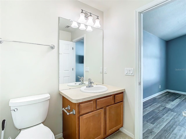 bathroom featuring wood-type flooring, vanity, and toilet