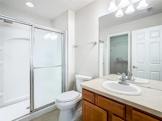 bathroom featuring toilet, an enclosed shower, and vanity