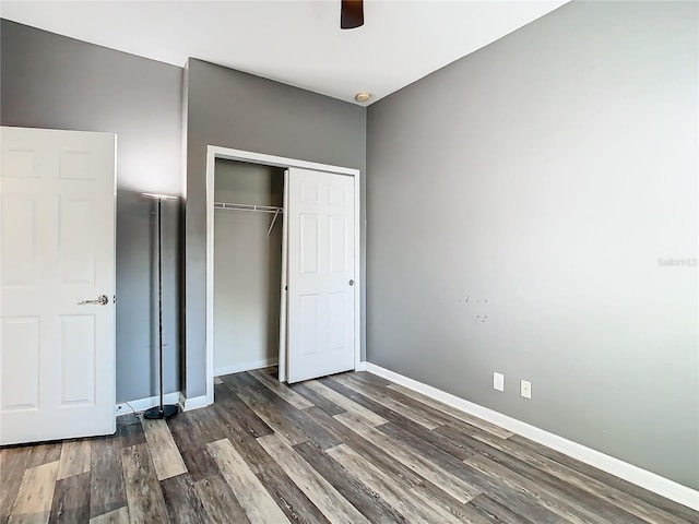 unfurnished bedroom with ceiling fan, a closet, and dark hardwood / wood-style flooring