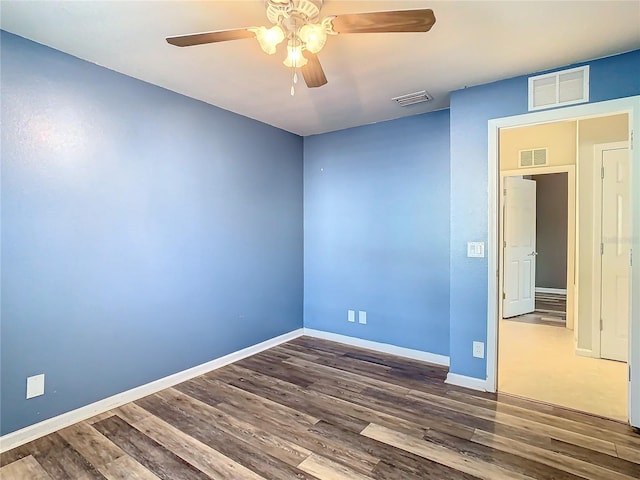 empty room featuring ceiling fan and dark hardwood / wood-style floors