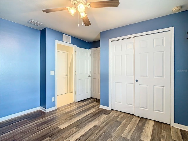 unfurnished bedroom featuring ceiling fan, a closet, and dark hardwood / wood-style floors