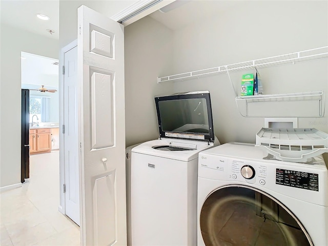 washroom with sink, ceiling fan, washing machine and clothes dryer, and light tile patterned floors