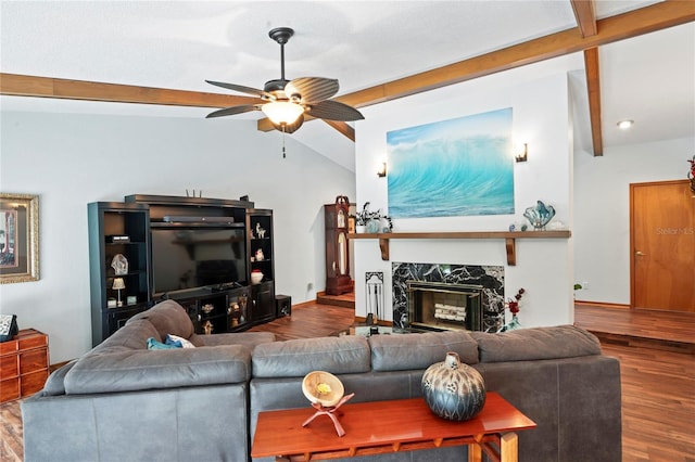 living room featuring ceiling fan, vaulted ceiling with beams, wood-type flooring, and a fireplace