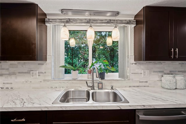 kitchen with stainless steel dishwasher, sink, a textured ceiling, and dark brown cabinetry