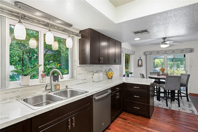 kitchen with pendant lighting, a textured ceiling, dishwasher, dark hardwood / wood-style flooring, and sink