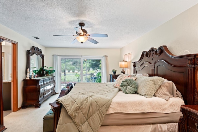 bedroom featuring a textured ceiling, ceiling fan, and light colored carpet