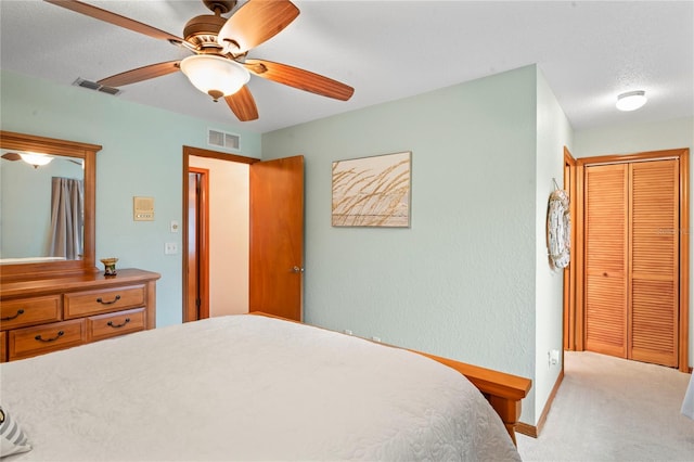 carpeted bedroom featuring ceiling fan, a closet, and a textured ceiling