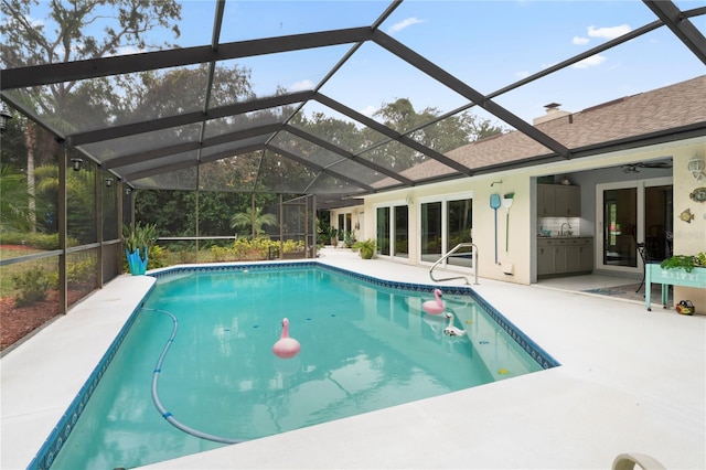 view of swimming pool with glass enclosure and a patio area