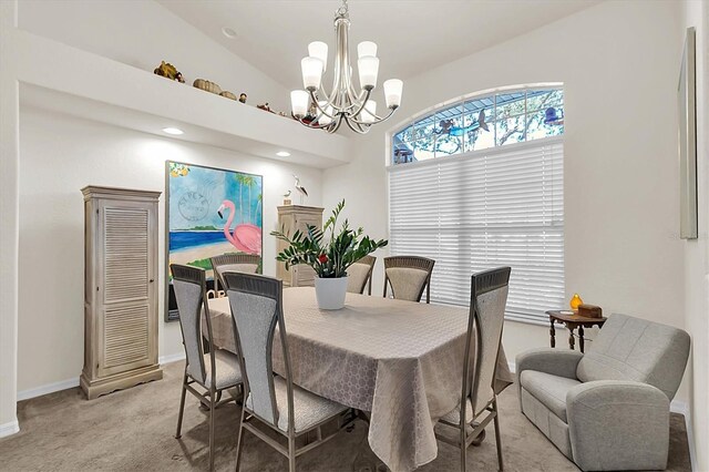 dining area featuring baseboards, lofted ceiling, light colored carpet, and an inviting chandelier