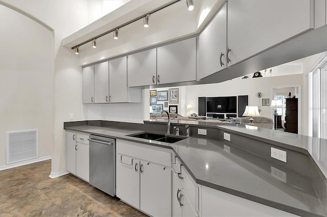 kitchen with visible vents, a sink, stainless steel dishwasher, dark countertops, and open floor plan