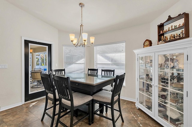 dining space with baseboards and a notable chandelier