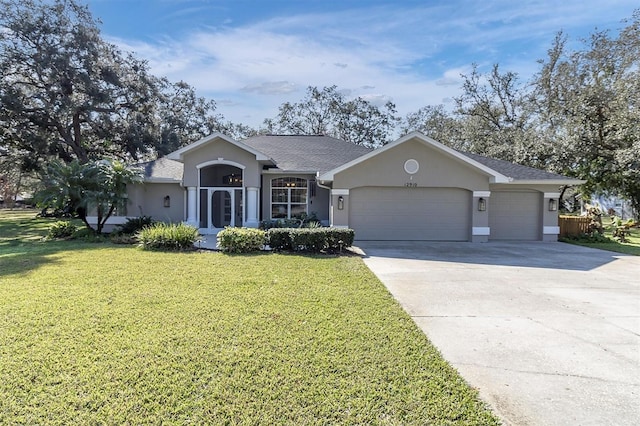 ranch-style house featuring stucco siding, driveway, a front yard, and a garage