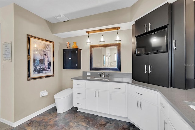 bathroom featuring visible vents, toilet, stone finish flooring, baseboards, and vanity