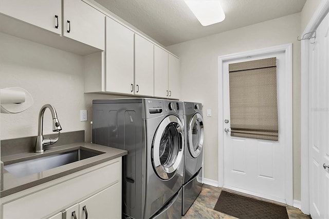 clothes washing area with a sink, baseboards, cabinet space, and independent washer and dryer